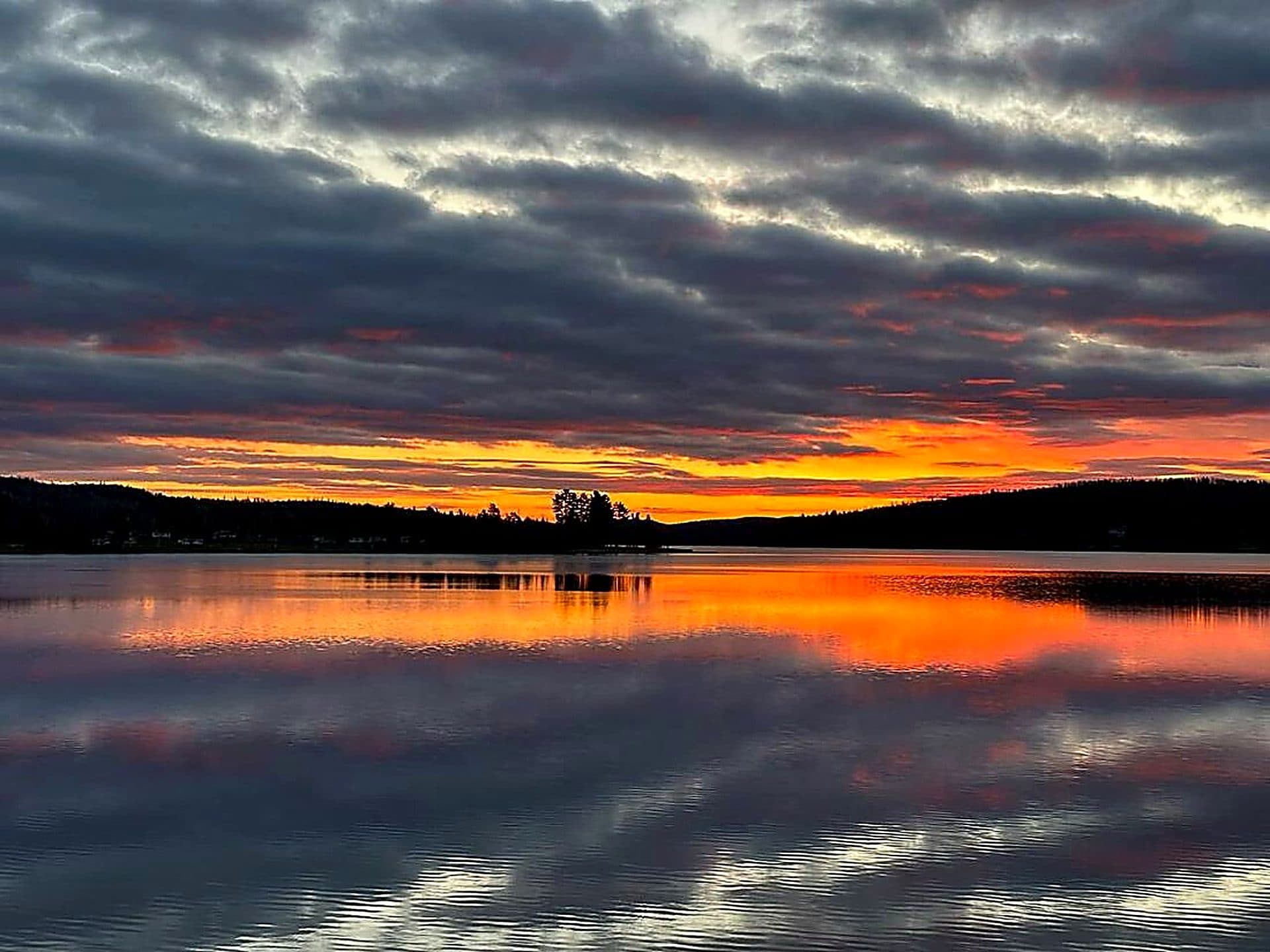 An orange and pink sunset reflected in Eagle Lake.